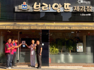 세류3동 지역사회보장협의체가 브리앙뜨과자점에 「사랑나눔가게」 현판을 전달하고 기념촬영을 하고 있다.