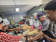 손대경 인계동장이 연무정급식소를 방문하여 반찬을 만들고 있는 봉사자들을 격려하고 있다.