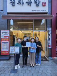 광교2동 행정복지센터에서 경자국밥에 사랑나눔가게 현판을 전달하는 모습.