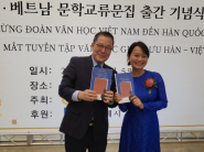 한국·베트남 양국 대표가 문학교류 작품집을 들고 기념촬영을 하고 있다(사진 왼쪽 김운기 수원문인협회 회장, 오른쪽 응우옌 티 타인 류 베트남작가회 대표).