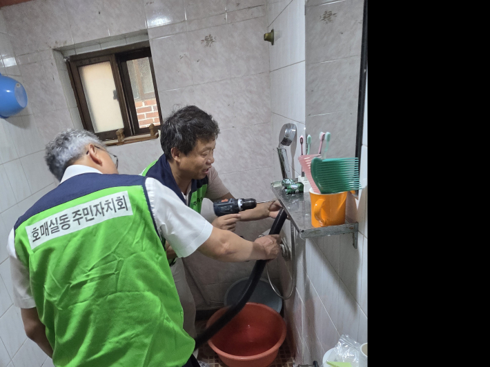최재근 회장과 맹석재 분과위원장의 화장실 안전손잡이 설치 모습