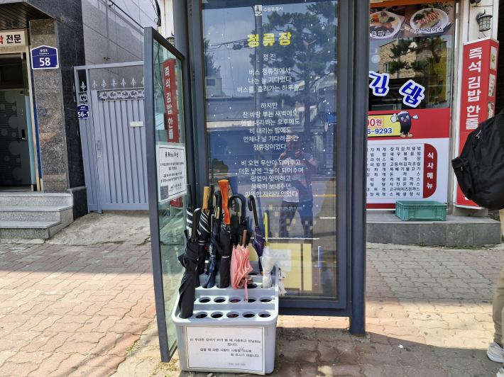 버스정류장에 누구나 쓸 수 있는 우산을 비치해 놓았다. 따뜻한 배려이자, 친절의 손길이다.