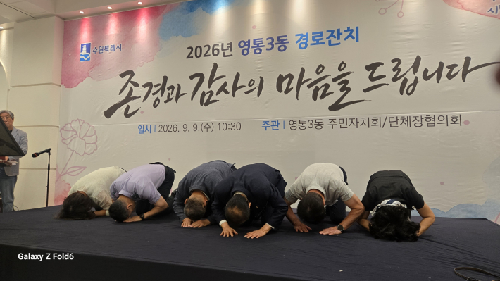 진성원 주민자치회장과 김인태 영통3동장 등 지역 단체장들이 무대 위에 올라 어르신들의 건강과 행복을 기원하며 큰절을 올리고 있다.