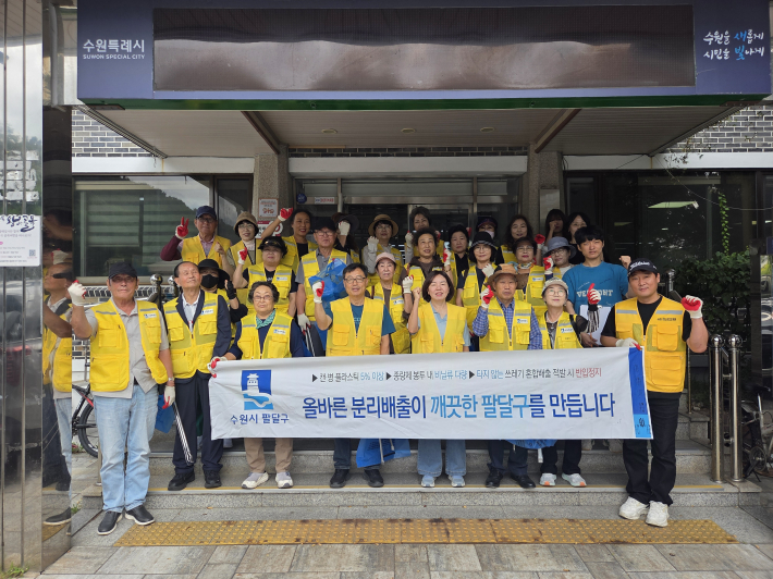  행궁동 통장협의회, 환경관리원, 동 직원들이 추석맞이 가을 대청소에 앞서 '추석맞이 가을 대청소' 현수막을 들고 기념촬영을 하고 있다.