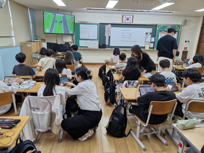 보조 강사로 참여한 주무관들이 태블릿에 서툰 학생들을 도와주고 있다.  