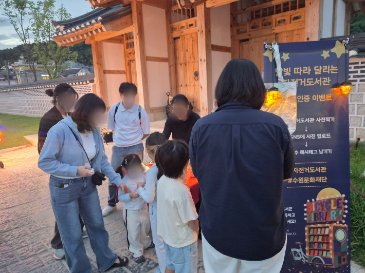 자전거 도서관을 살펴보고 SNS 인증 이벤트에 참여하기 위해 시민들이 모여들고 있다.