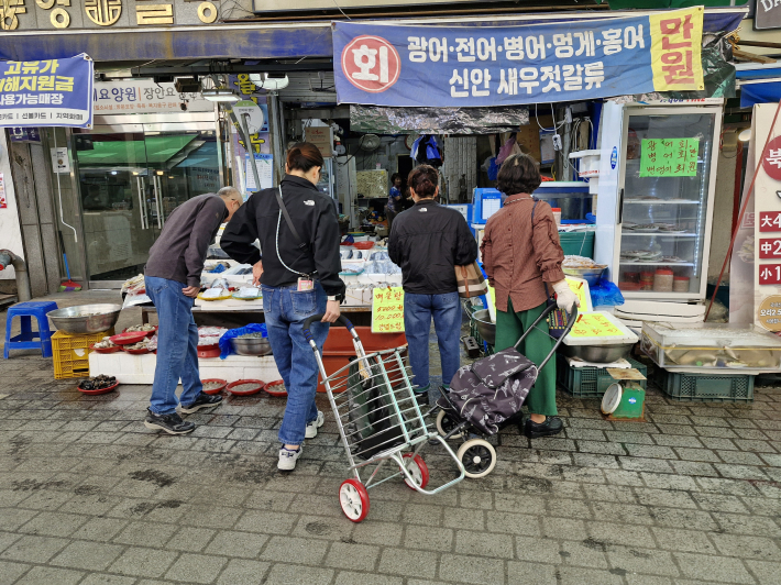 북수원 시장에서 수산물을 고르고 있는 손님들.