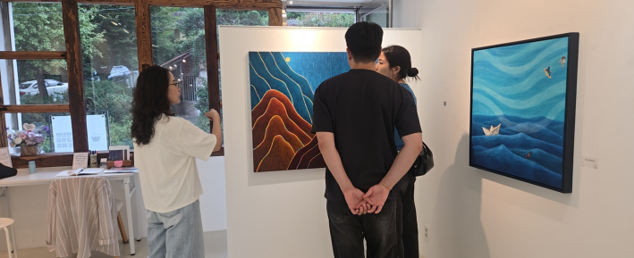 최경숙 작가가 관람객들에게 작품 세계와 스크레치 기법을 설명해 주고 있다