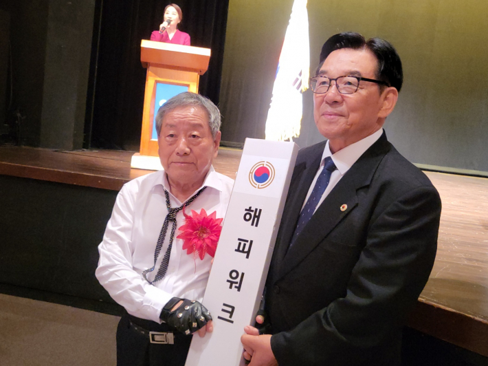 임헌우 회장이 경진대회 최고령 참가 어르신에게 장수지팡이를 전달하고 기념촬영을 하고 있다.