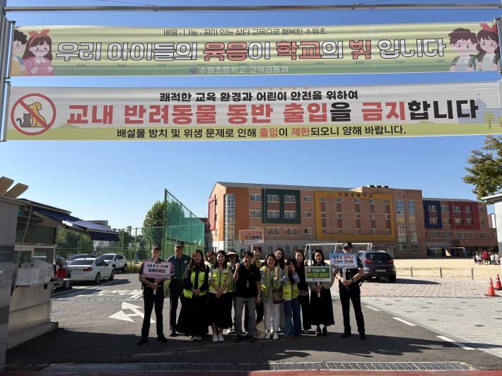 9월 15일 수원초등학교 등굣길 안전캠페인에 함께한 학교 관계자와 학부모, 고등파출소 경찰관들이 교통안전 문구가 적힌 팻말을 들고 기념촬영을 하고 있다.