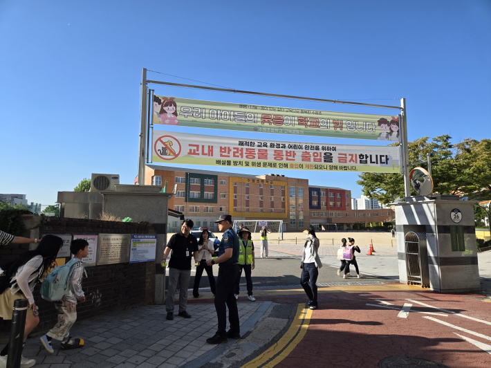 9월 15일 오전 수원초등학교 정문에서 캠페인 참여자들과 경찰관이 등교하는 학생들을 맞이하고 있다.