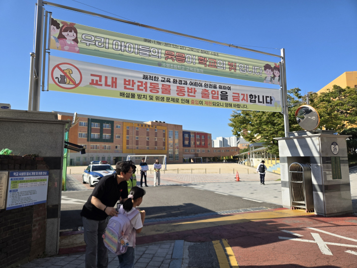 송상호 수원초등학교 교장이 정문에서 등교하는 학생을 따뜻하게 맞이하고 있다.