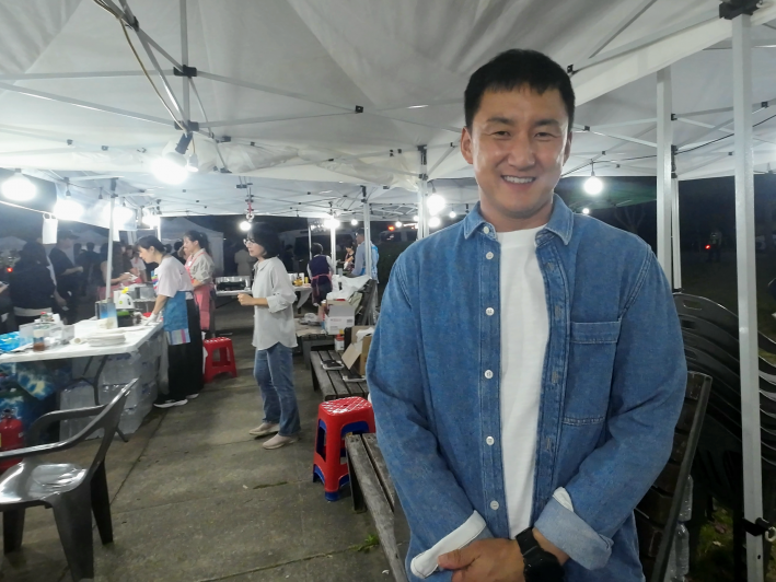 광교2동 주민자치회 먹거리 부스 운영을 총괄한 김병직 주민자치회장이 인터뷰에 응하고 있다.