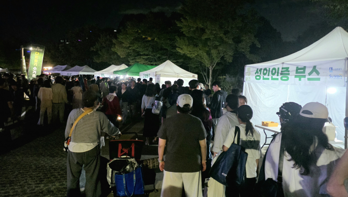 성인인증 부스 옆 다회용기 부스에 분류 수거 배출을 하기 위해 시민들이 줄을 서고 있다.