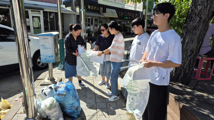 조원1동에서 외국인들에게 올바른 분리수거 방법에 대해 안내하고 있다.