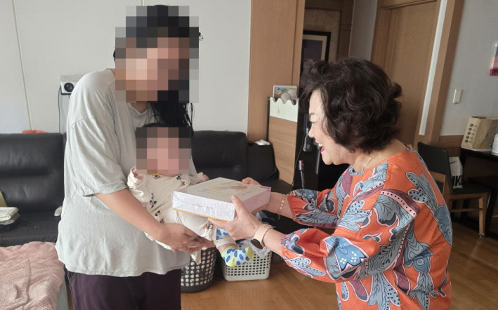 서둔동 지역사회보장협의체 위원장이 출산선물을 전달하고 있다.