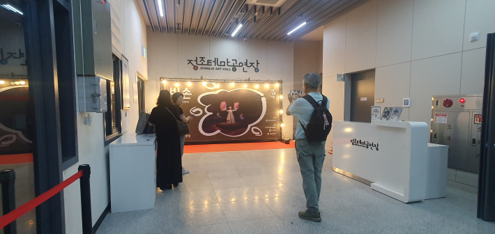 《비손》 공연을 찾은 관람객들이 정조테마공연장 로비에서 공연 안내물을 살펴보고 있다.
