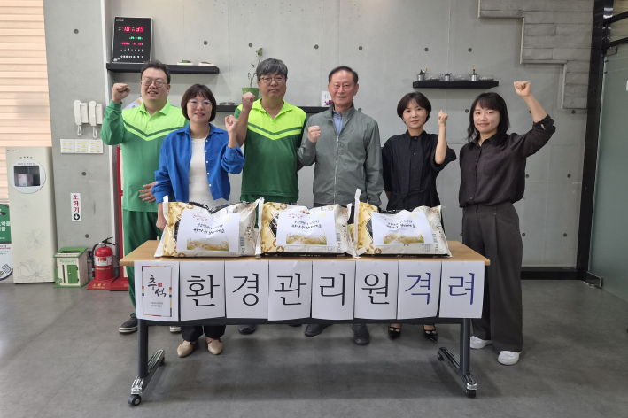 송죽동 주민자치회가 동 환경관리원에게 감사의 쌀을 전달한 뒤 기념촬영을 하고 있다.