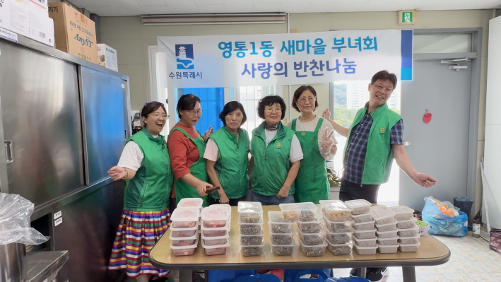 강경임 영통1동 새마을부녀회장(가운데)과 회원들이 구민서 마을만들기협의회장(왼쪽 끝), 김영진 마을만들기협의회 고문(오른쪽 끝)과 함께 기념 촬영을 하고 있다.
