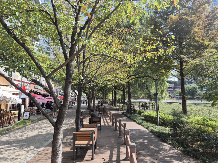 바람개비 상가 주변 테이블에는 음료와 음식이 놓이고, 잠시 쉬어가는 사람들이 보인다.