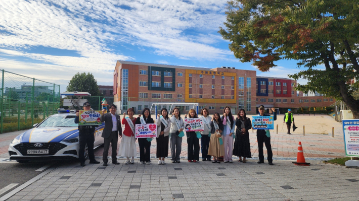 수원초 학교폭력 예방 캠페인에 참여한 학부모회와 녹색학부모회 관계자, 학생, 고등파출소 경찰관들이 피켓을 들고 기념촬영을 하고 있다.