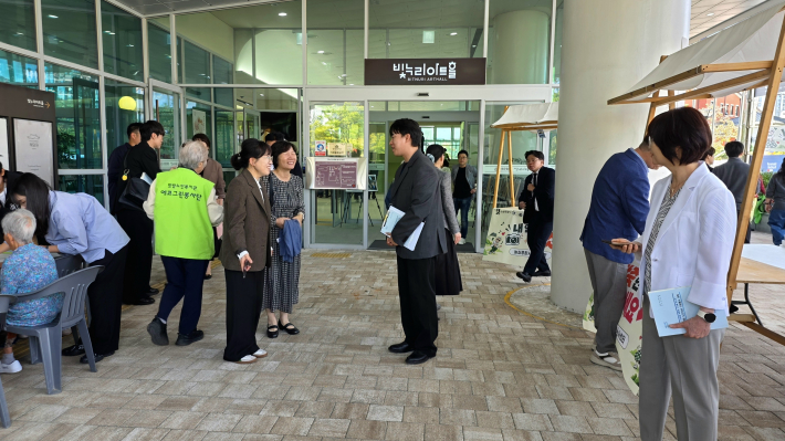 행사장을 찾은 내빈 및 어르신들이 서로 안부를 나누고, 로비와 야외 광장에 마련된 체험부스를 둘러보고 있다. 