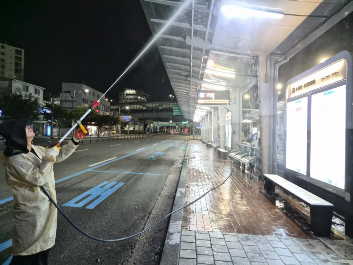 수원역 인근 버스승강장을 세척하고 있다.