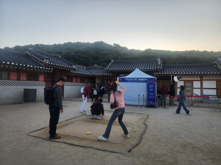 화성행궁 내 전통놀이 체험 공간에서 관람객들이 딱지치기를 즐기고 있다.