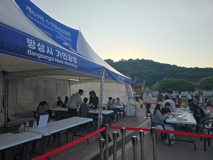 제63회 수원화성문화제 '방상시 가면공방'에서 어린이와 보호자들이 가면 만들기를 체험하고 있다.