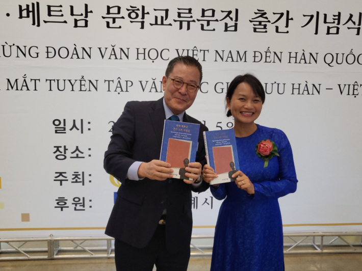한국·베트남 양국 대표가 문학교류 작품집을 들고 기념촬영을 하고 있다(사진 왼쪽 김운기 수원문인협회 회장, 오른쪽 응우옌 티 타인 류 베트남작가회 대표).