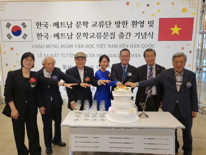 수원문인협회 고문들과 함께 문학교류 작품집 출간을 축하하며 케이크를 자르고 있다.  