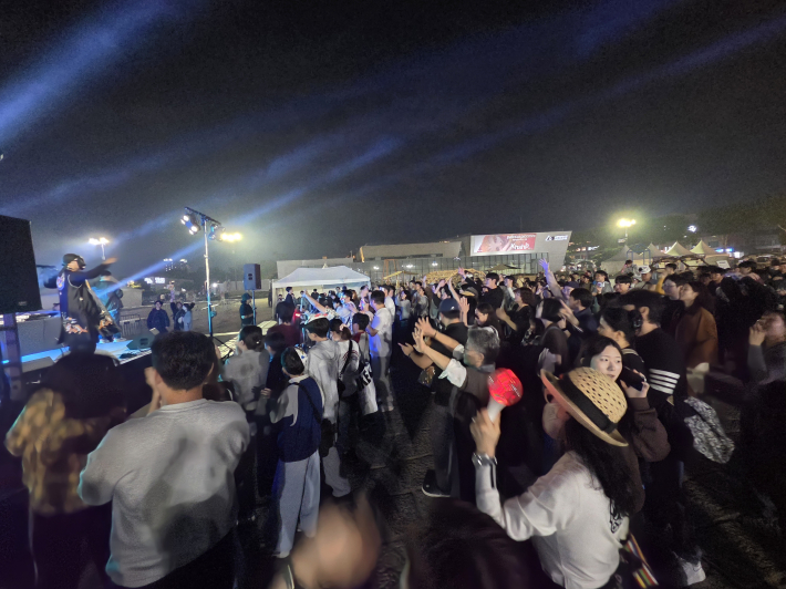 손을 높이 들어 흔들고, 리듬에 맞춰 몸을 움직이며 축제 즐겨    