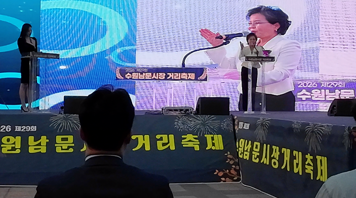 김미경 수원특례시의회 의장이 단상에서 전통시장 활성화와 축제 개최를 축하하며 축사를 전하고 있다.