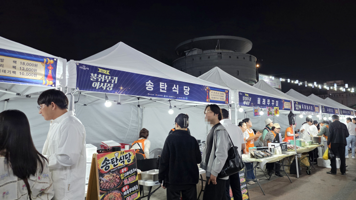 남문장터에 조성된 야시장 먹거리에서 방문객들이 음식을 주문하고 즐기는 활기찬 모습이다.