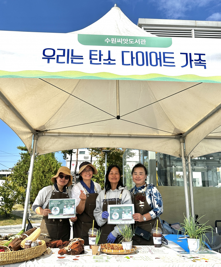 수원씨앗도서관 관계자들이 다양한 씨앗을 소개하며 기념촬영을 하고 있다.