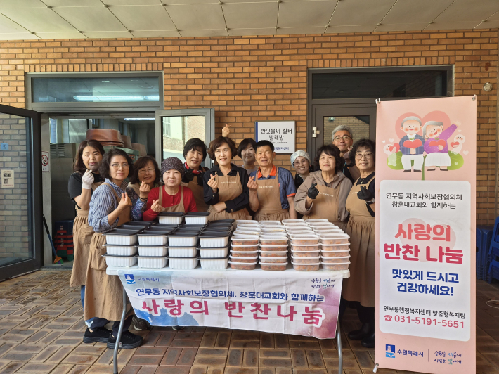 연무동 지역사회보장협의체 위원들이 반찬나눔행사 사진을 찍고 있다