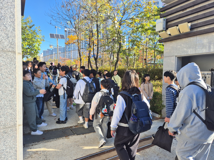 학생들이 학교 정문 앞에서 등굣길 인사 캠페인을 진행하며 따뜻한 학교문화 조성에 앞장서고 있다.