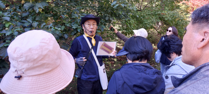 이정우 해설사가 참빗살나무를 해설하며 생활용품 참빗을 보여주고 있다.