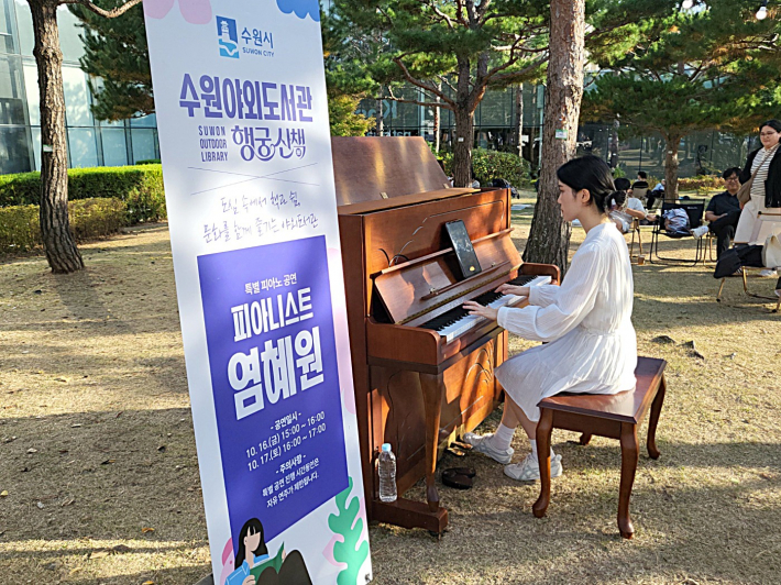 미술관 옆 공원에서 피아니스트 염혜원이 감미로운 피아노 선율로 야외도서관의 분위기를 더하고 있다.