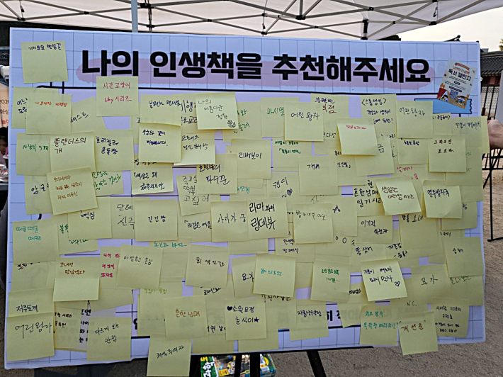 '나의 인생책을 추천해 주세요' 코너에서 시민들이 추천 도서를 포스트잇에 적어 화이트보드에 붙이고 있다.