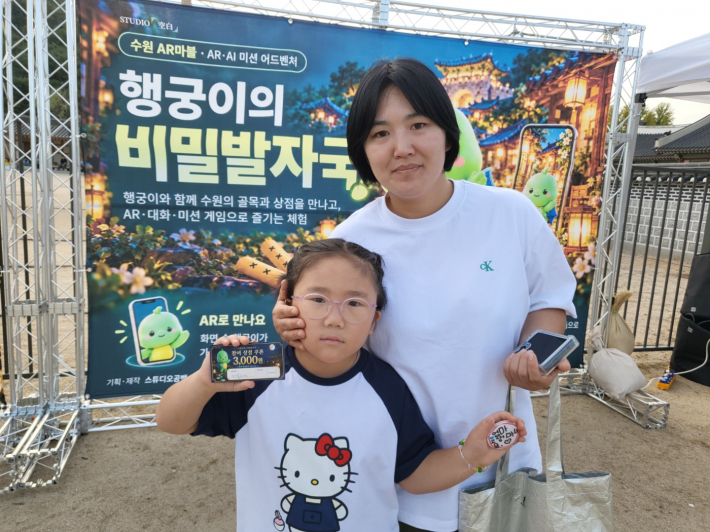 유치원생 어린이는 엄마와 함께 체험 활동을 즐기고 만든 기념품을 들어보이고 있다.