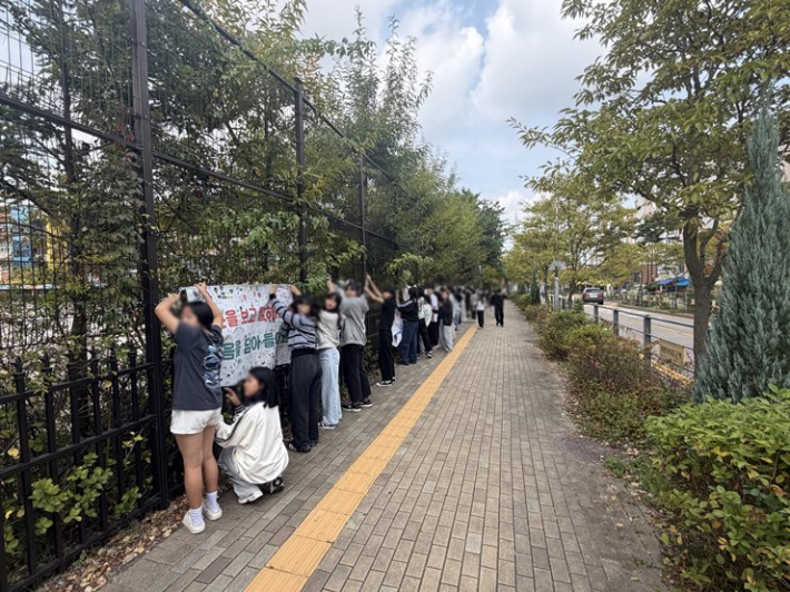 수원중촌초, 언어폭력예방교육주간 '형제학년 공동현수막' 을 학교 담장에 게시하고 있다.