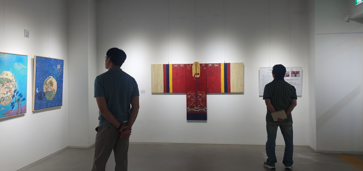 혼례복 활옷을 회화로 재해석한 강남철 작가의 작품을 관람하는 모습