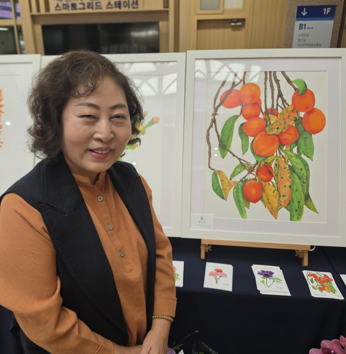 황순금 회장이 자신의 작품에서 환하게 웃고 있다.  