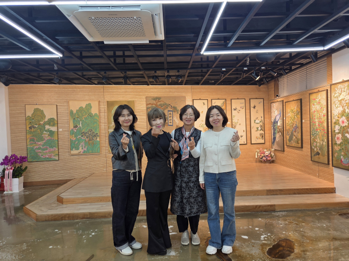 최영희 행궁동장(오른쪽 첫 번째), 천영숙 '이음' 관장(왼쪽 두 번째), 안금녀 작가(오른쪽 두 번째) 및 전시 관람객들이 기념촬영을 하고 있다.