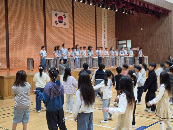 수원중촌초 5학년은 무대에서 난타공연을, 다른 학생들은 노래에 맞춰 플래시몹을 하고 있다.