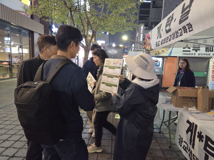 시민들이 쓰레기 분리수거에 대한 퀴즈를 맞추고 있다.