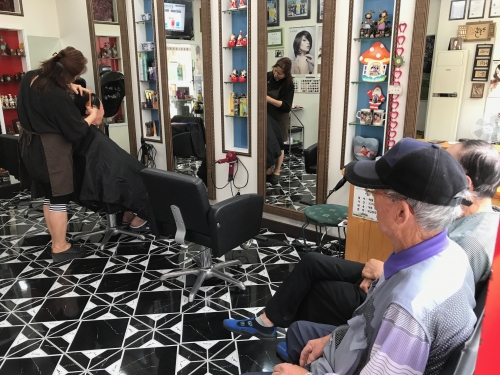 머리 손질을 받고 있는 노인들